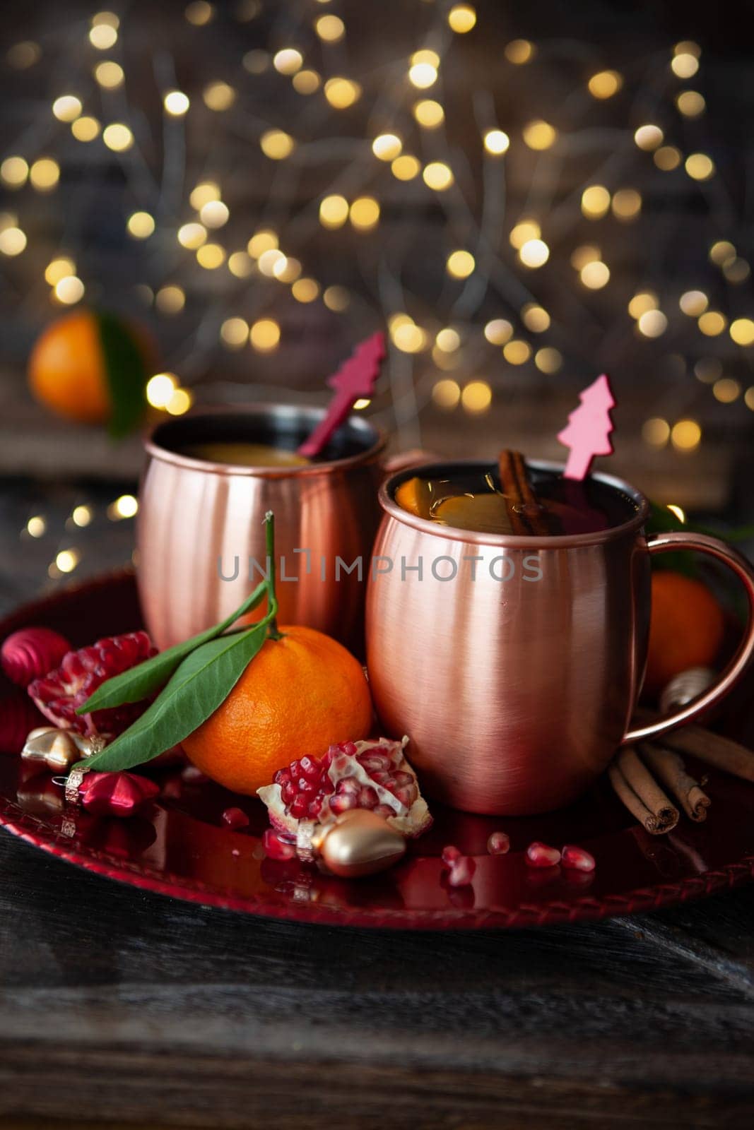 Two mugs of mulled wine with cinnamon and pomegranate