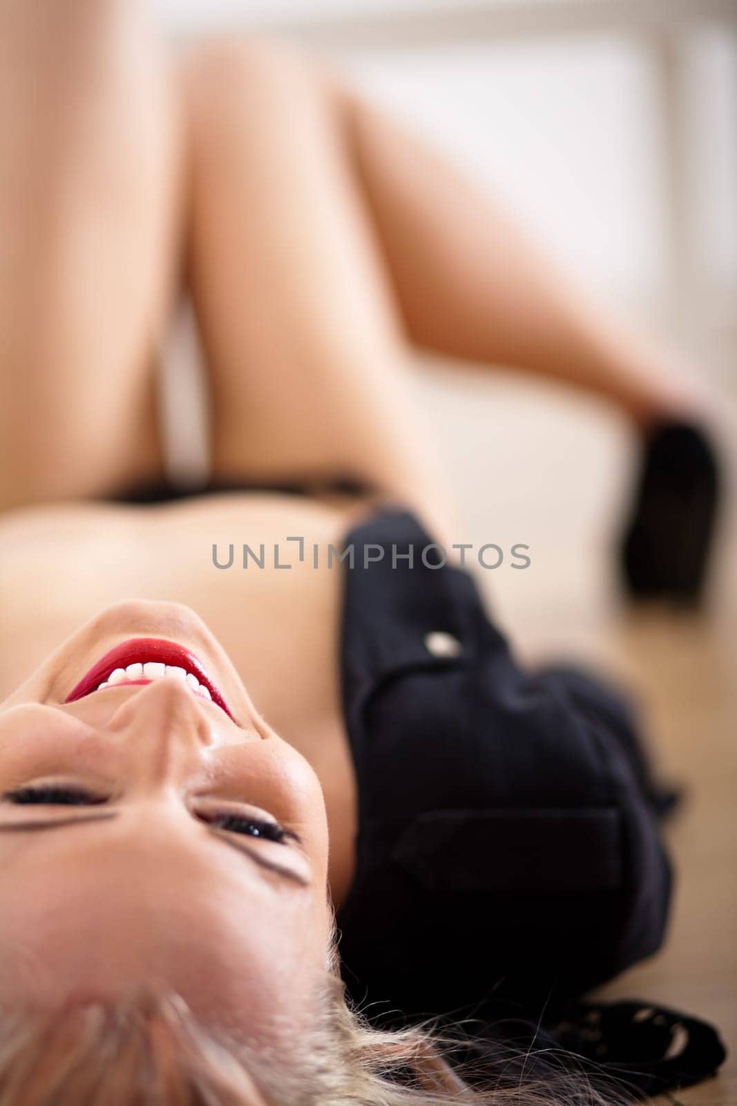 beautiful blonde young sexy woman posing on black dress and nude skin smiling