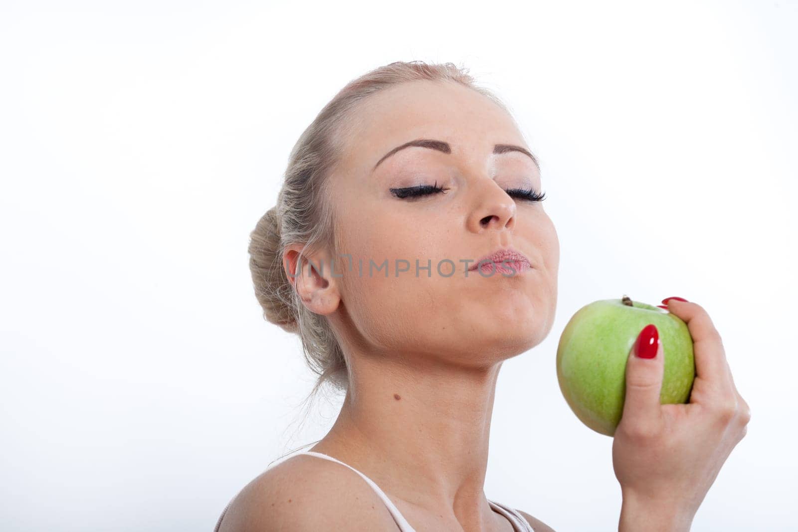 beautiful young blonde girl tasting a gorgeous red apple