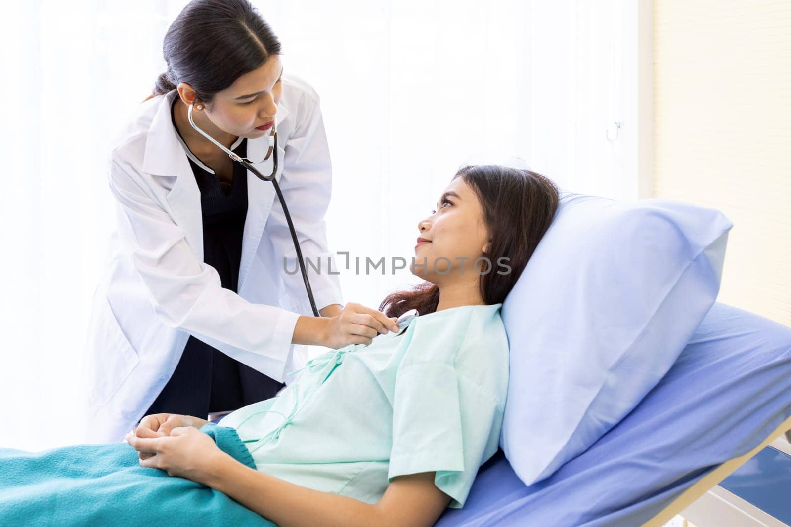 Asian Doctor make routine health check with patient in hospital ward
