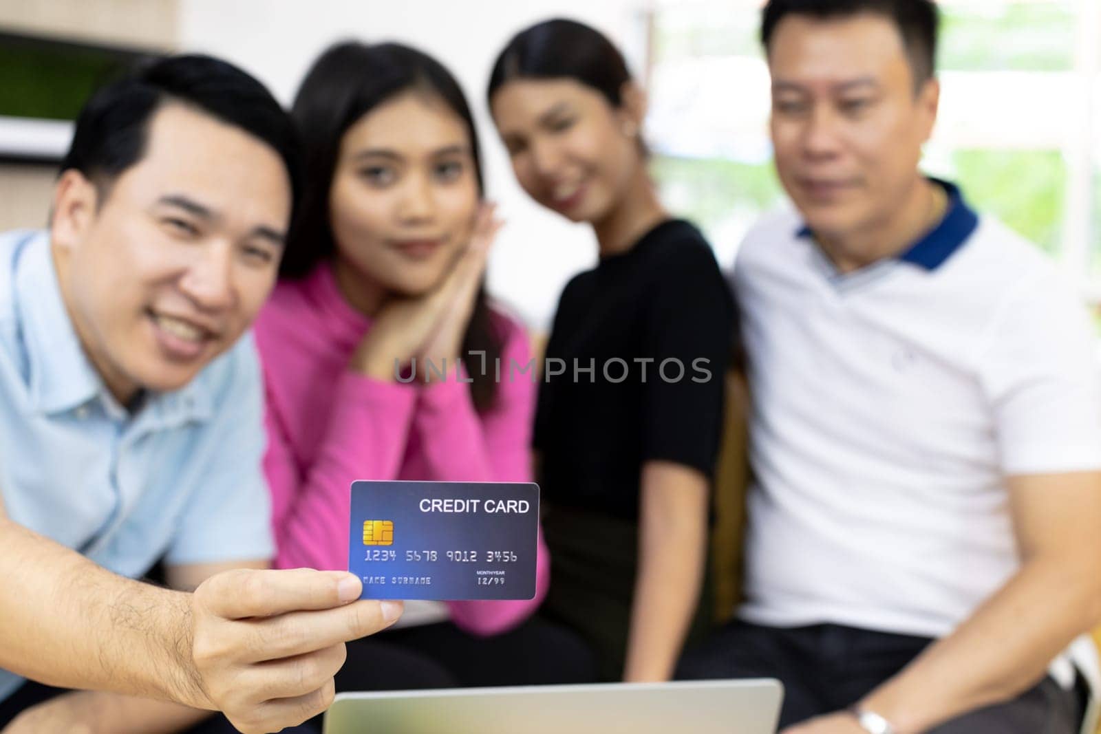 Young freelance group using credit card for paying in cafe. Selective focus on credit card