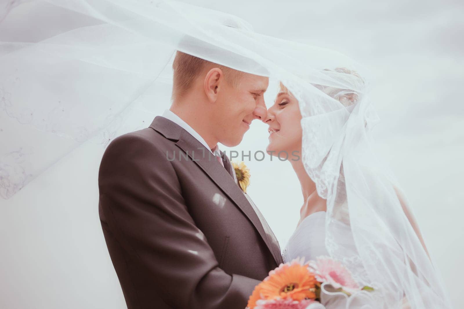 Kissing wedding couple in high grass