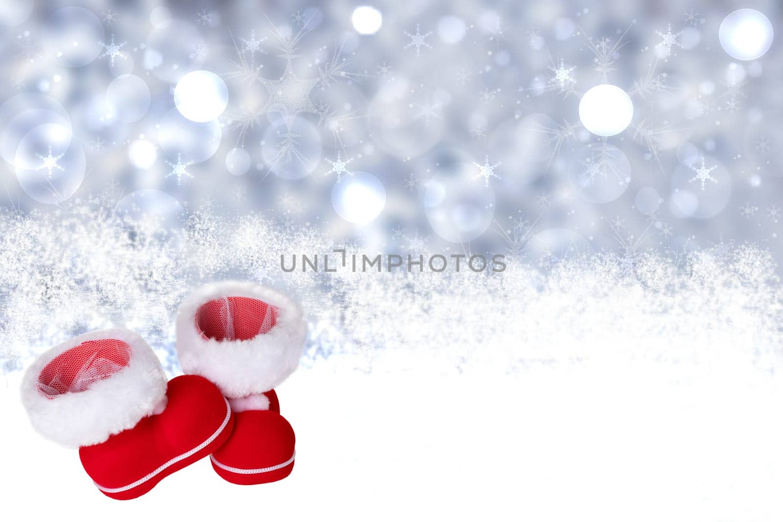 Winter background. Christmas winter background with red Cristmas boot or Santa Claus boots on wooden snowy board over abstract white festive xmas background. Space for your product display montage.