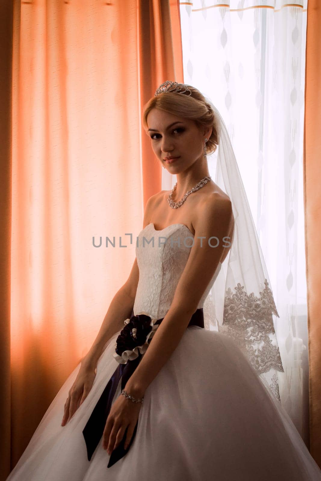 bride in a beautiful dress near the window