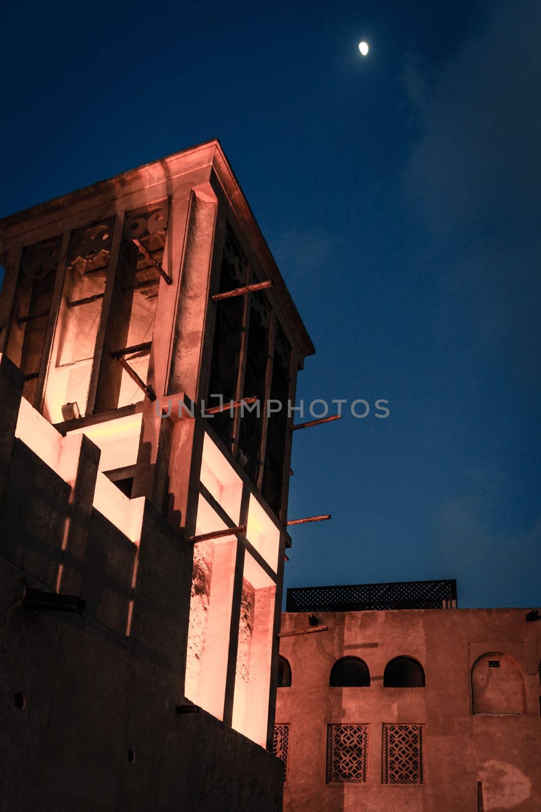 Moon over traditional buildings of Al Bastakiya district of old Dubai