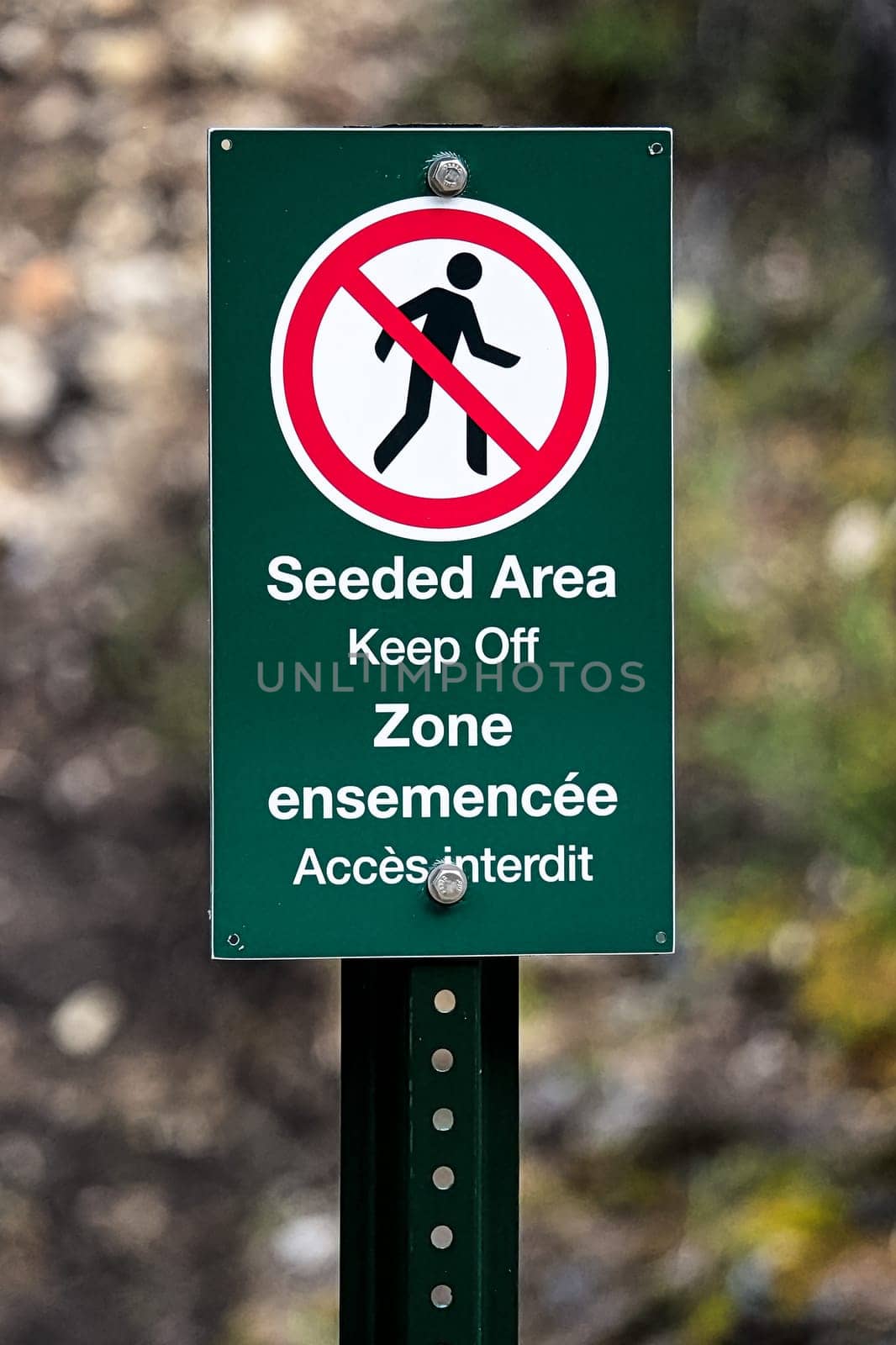 A seeded area keep off sign in french and english.