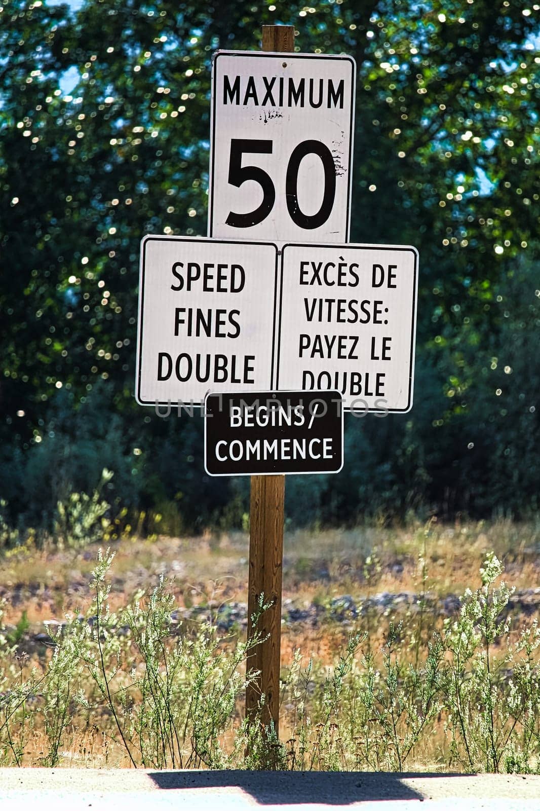 A Speed Fines Double Begins sign along a highway.