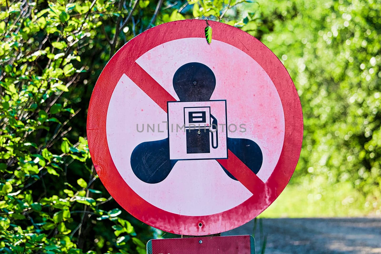 A no gas motors sign at lake with a small hook hanging.