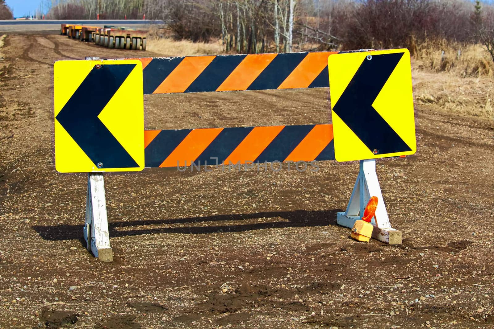 Detour construction barricade along a gravel road.