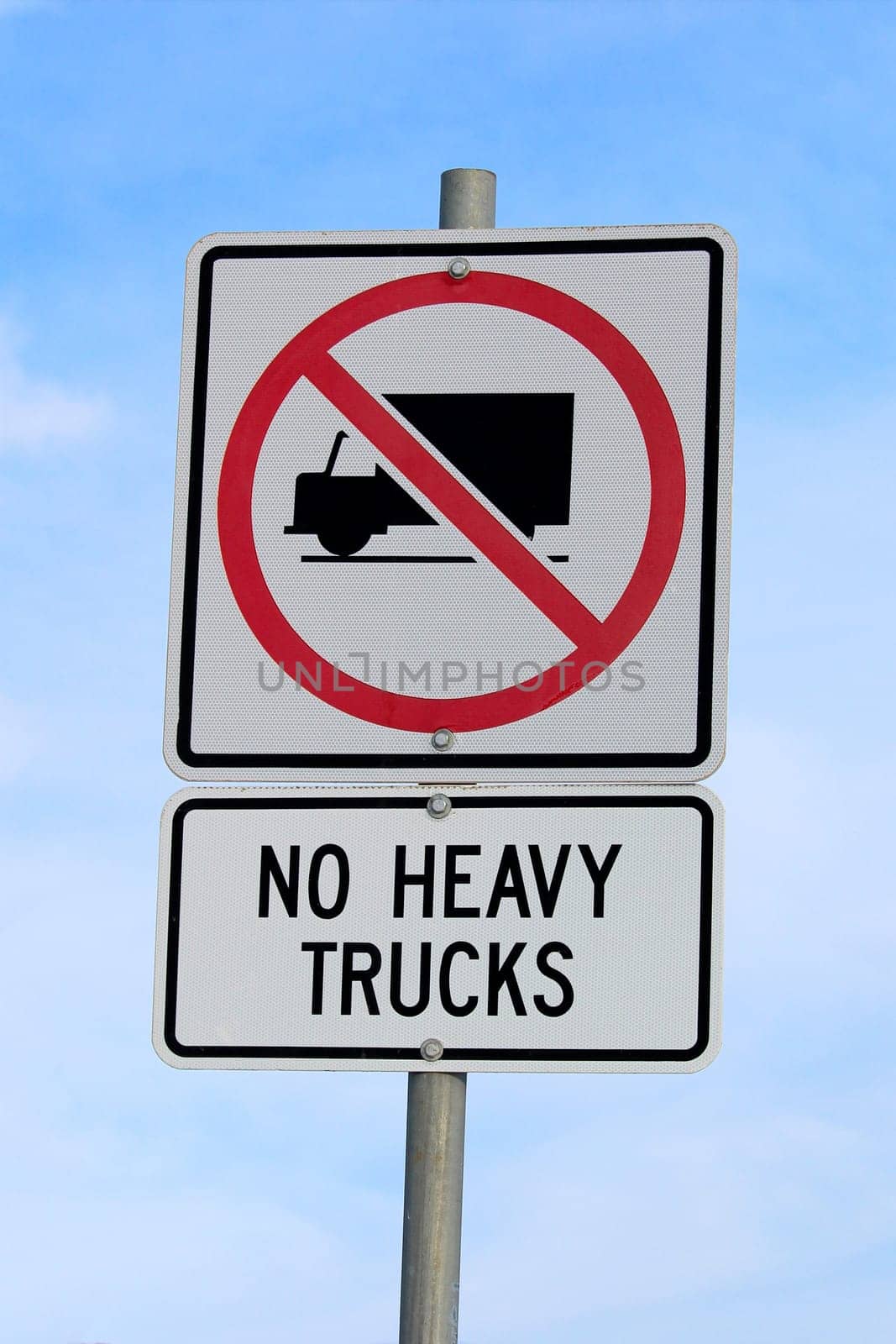 No Heavy Trucks Sign against Cloudy Blue Sky Background.