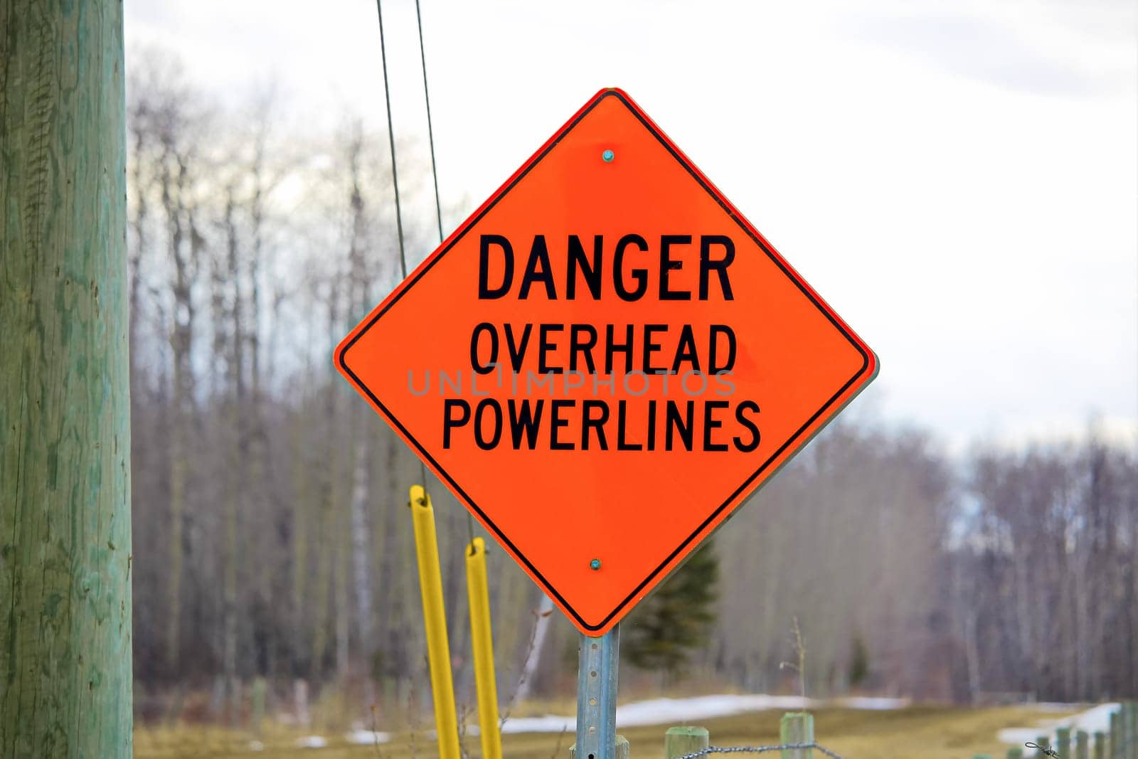 Danger overhead powerline sign beside a power pole.
