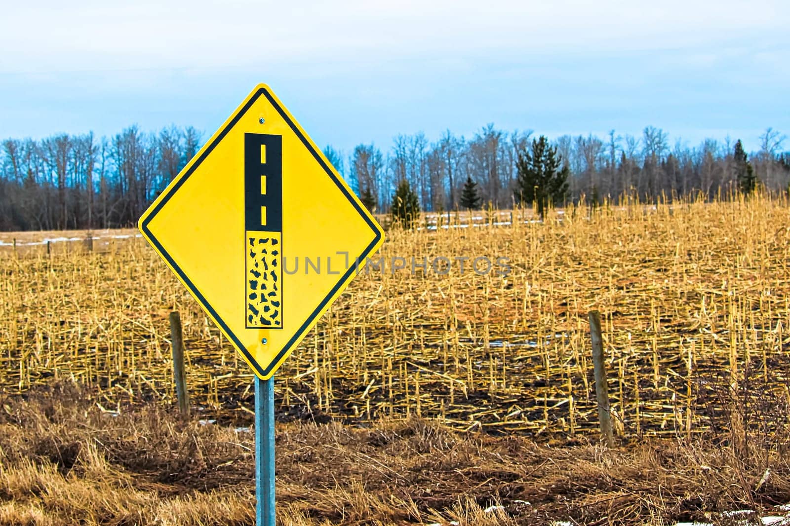 End of gravel road ahead warning sign.