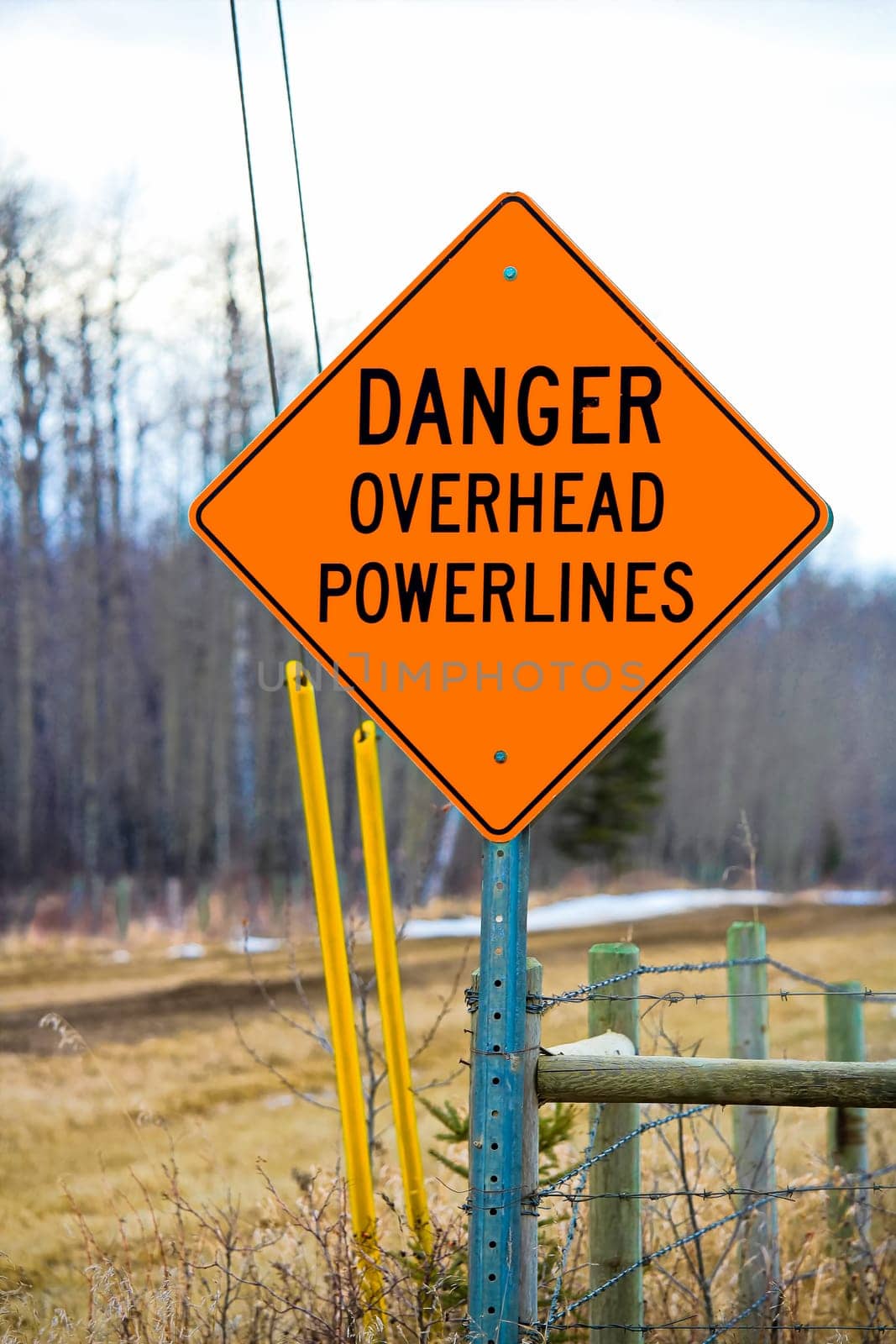 Danger overhead powerline sign beside a driveway.
