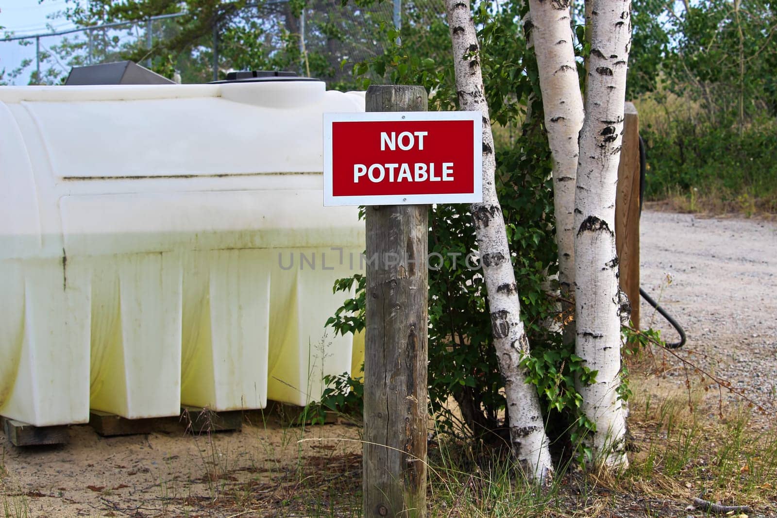 A not potable sign next to a water holding tank.