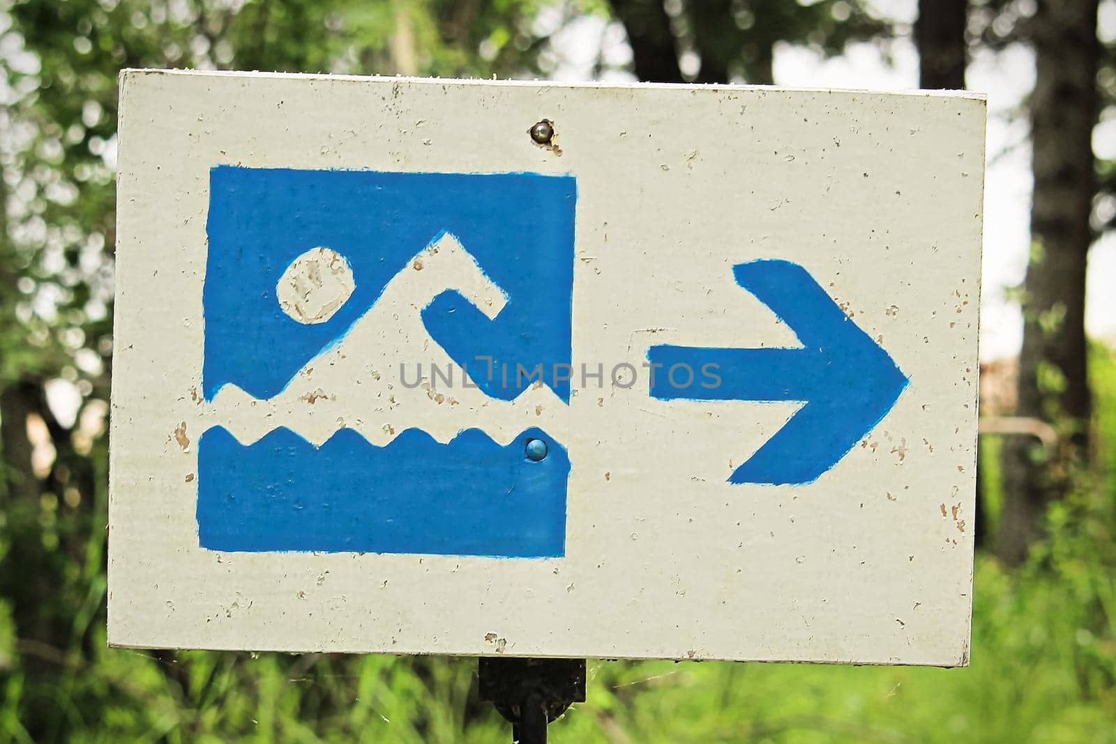 A blue beach beach sign with a direction arrow.