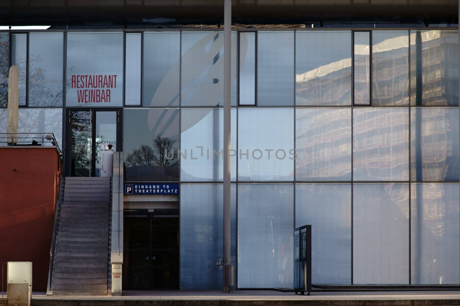 Aschaffenburg, Germany - November 17, 2018: The modern glass facade of the Municipal Theater Aschaffenburg with the entrance to a wine bar and a restaurant on November 17, 2018 Aschaffenburg..