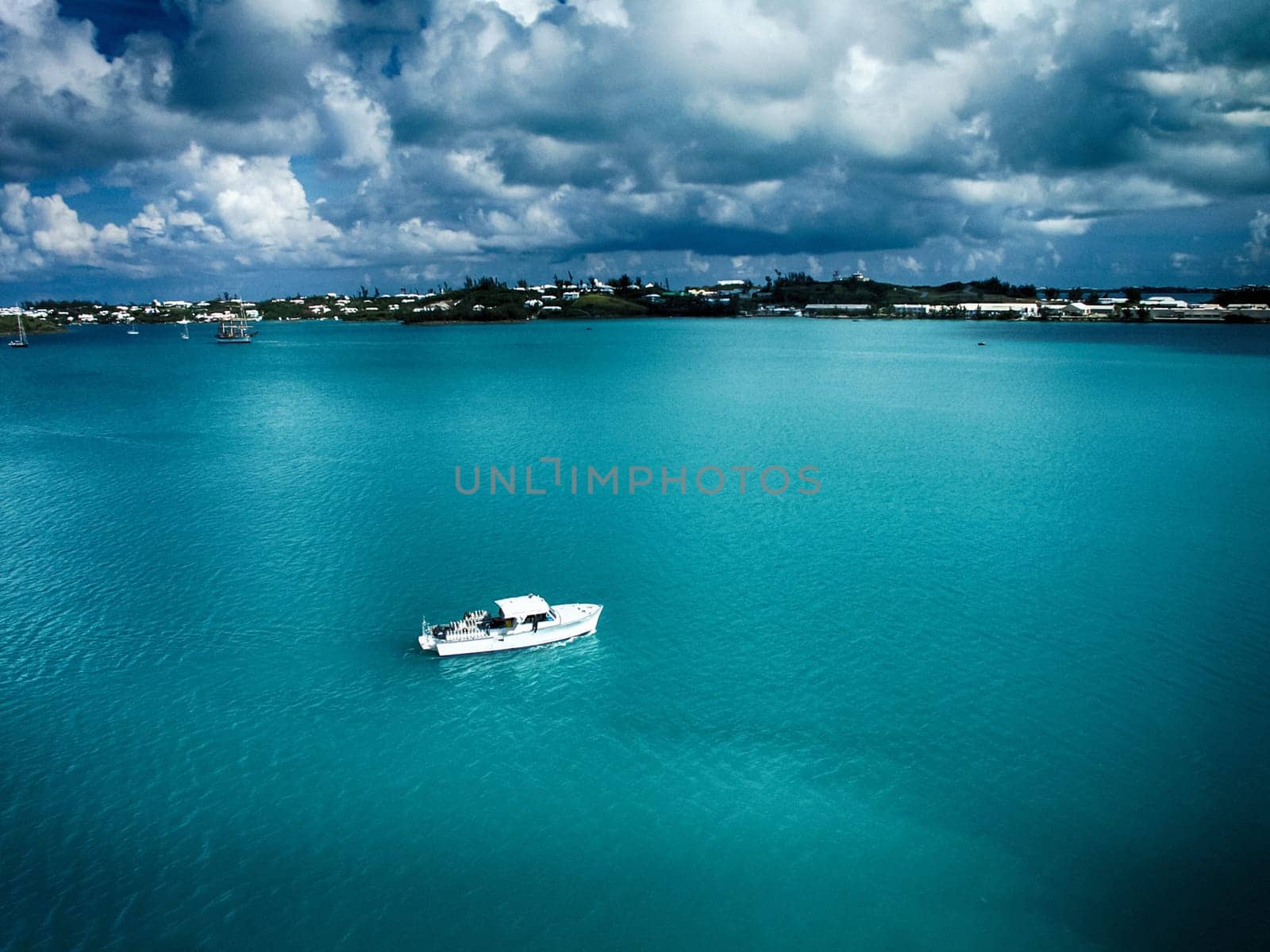 Boat on calm azure water surface. Ocean bay