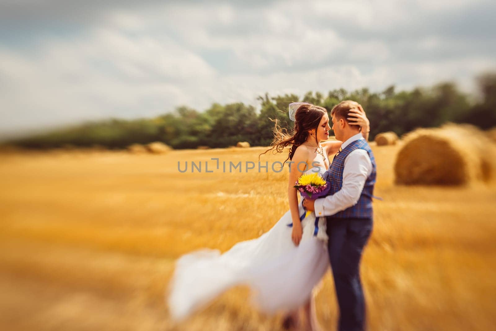 bride and groom near hay barn