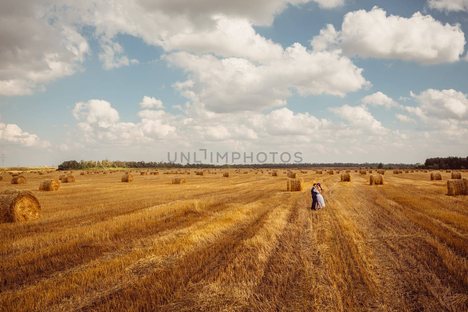 bride and groom near hay barn