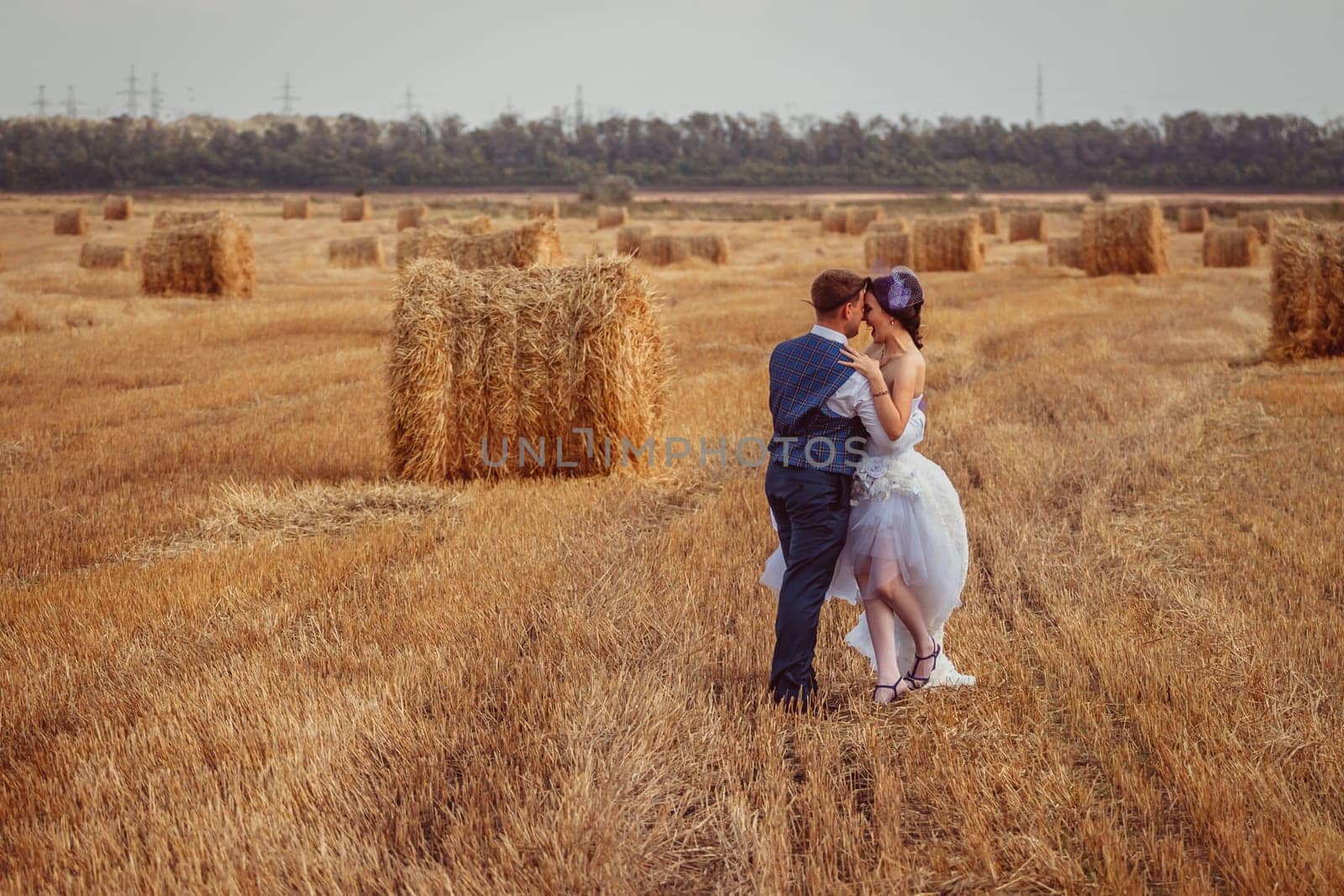 bride and groom near hay barn