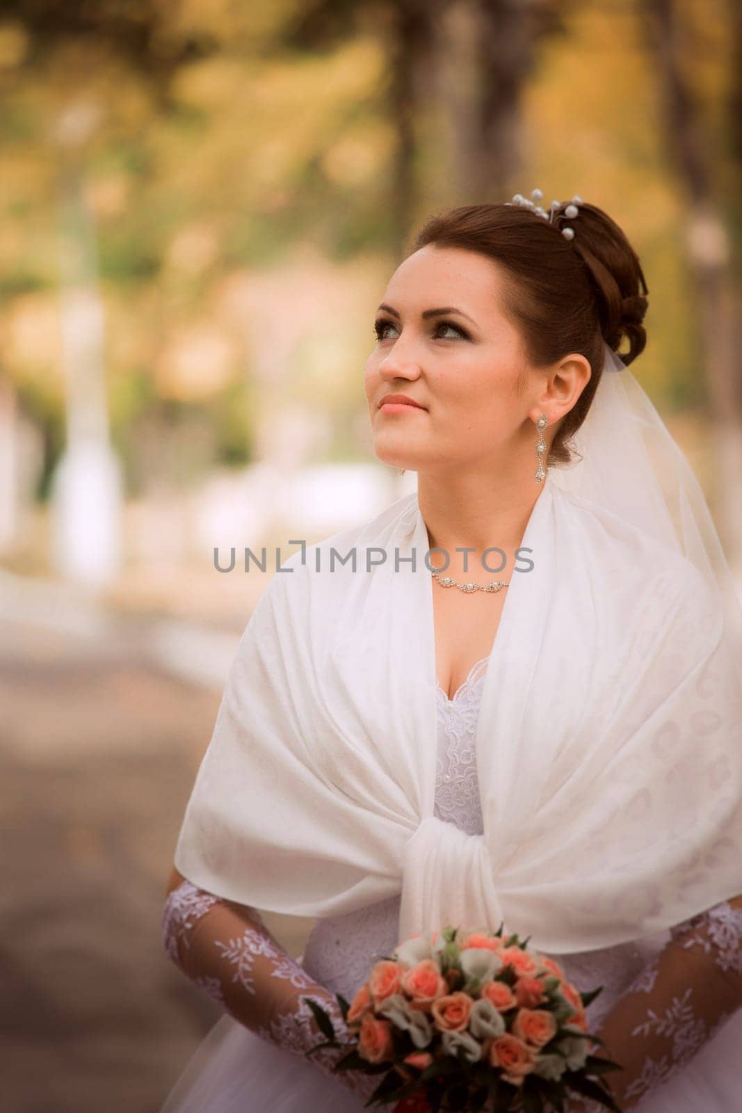 Beautiful bride in wedding dress and bridal bouquet, happy newlywed woman with wedding flowers, woman with wedding makeup and hairstyle. gorgeous young bride outdoors. Bride waiting for groom. bride