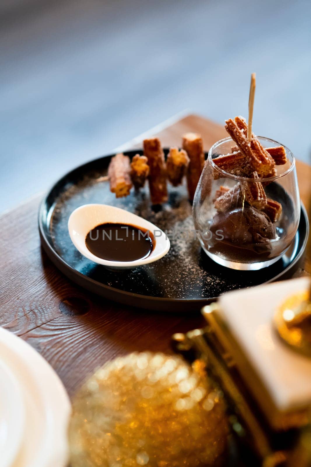Elegant Churros with Sugar and Chocolate Sauce on Fancy Display in Glass and Plate Gastronomy Close