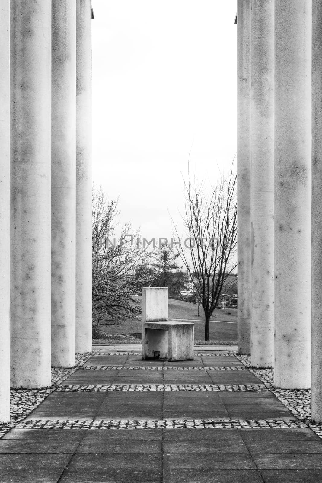 Cement Columns Chair Rough Texture Perspective Overhead Grid Geometric Pattern Design Outdoor Park Public Upright Minimal Bright Stone
