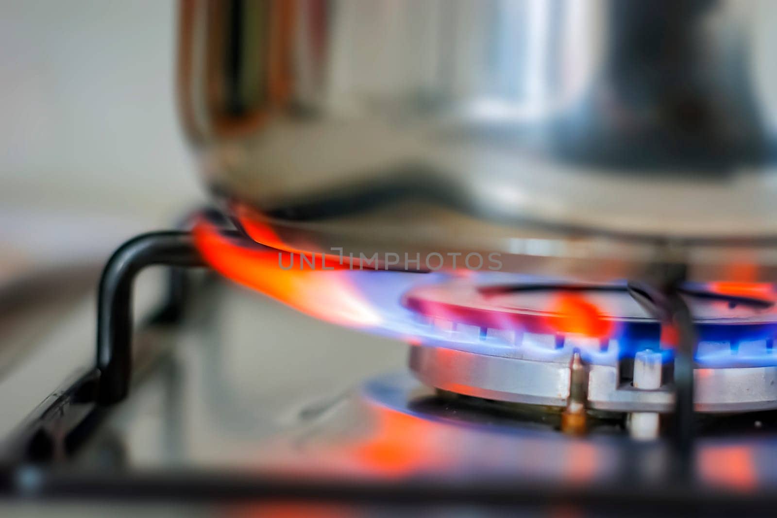 Blue glowing flame burning from the kitchen cooker. Gas and fire. Cooking concept. Interior domestic shot