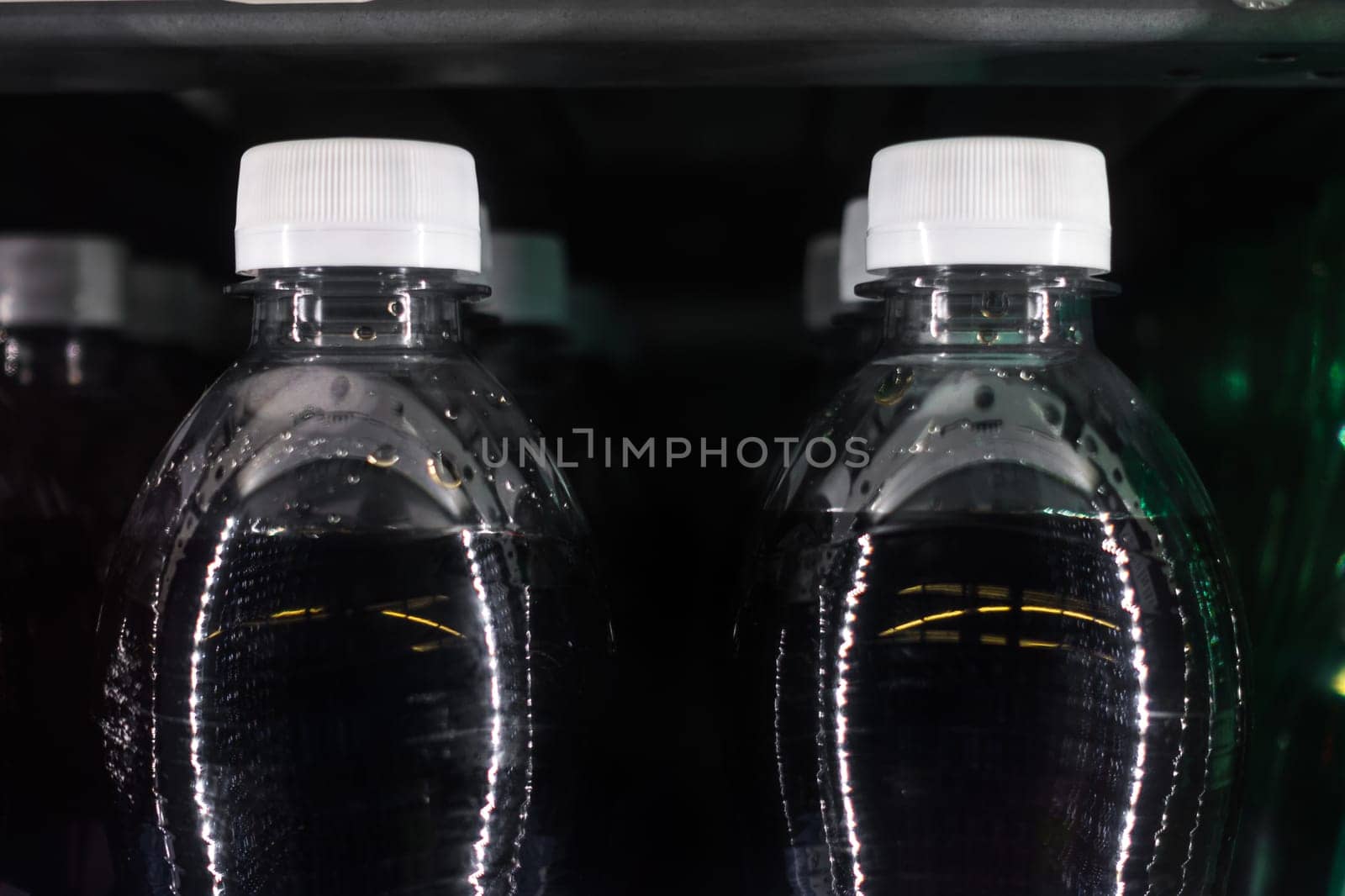 Soda Bottles in Vending Machine White Bottle Caps Black Liquid Rows