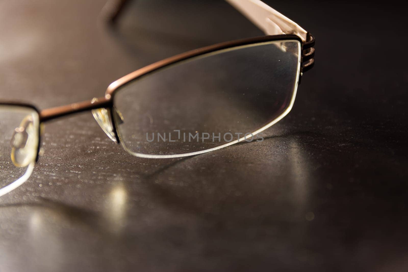 Brown Stylish Reading Glasses Setting on Black Desktop Workspace Empty Quiet