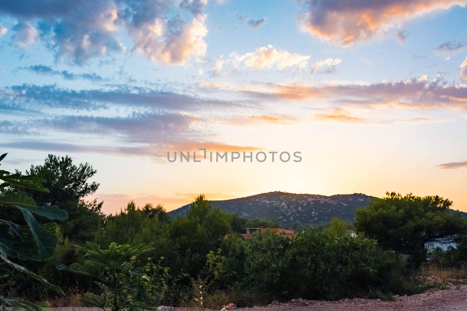 Beautiful Sunset Clouds over Mountains and Ocean in Croatia with Fiery Colors on Landscape