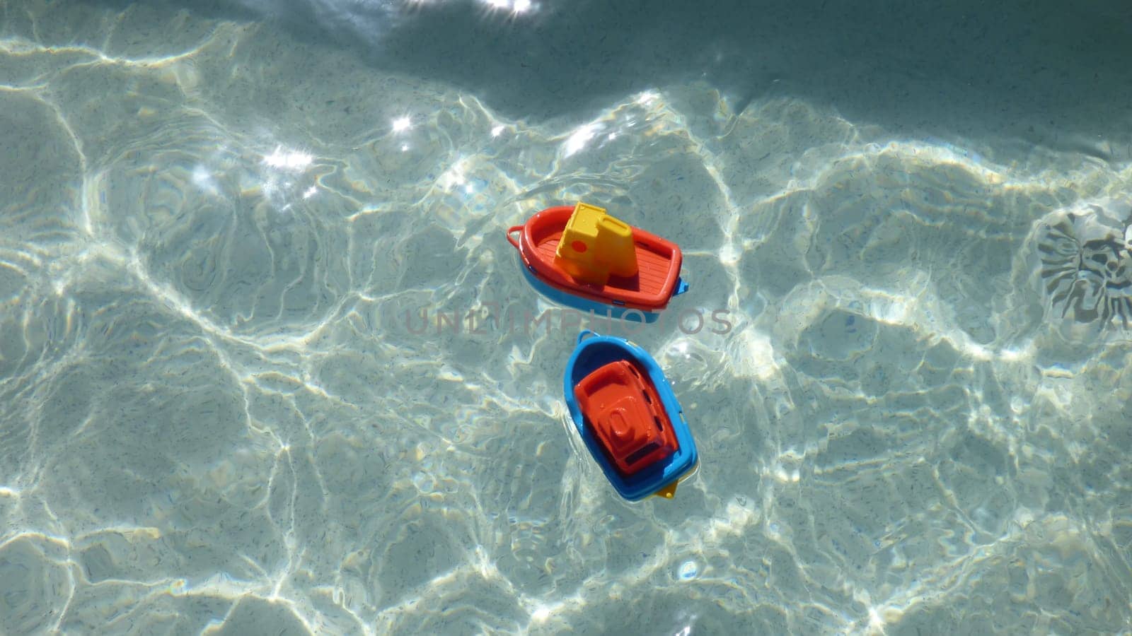Children's Beach Toy Boats Bright Colored Floating in Clear Water