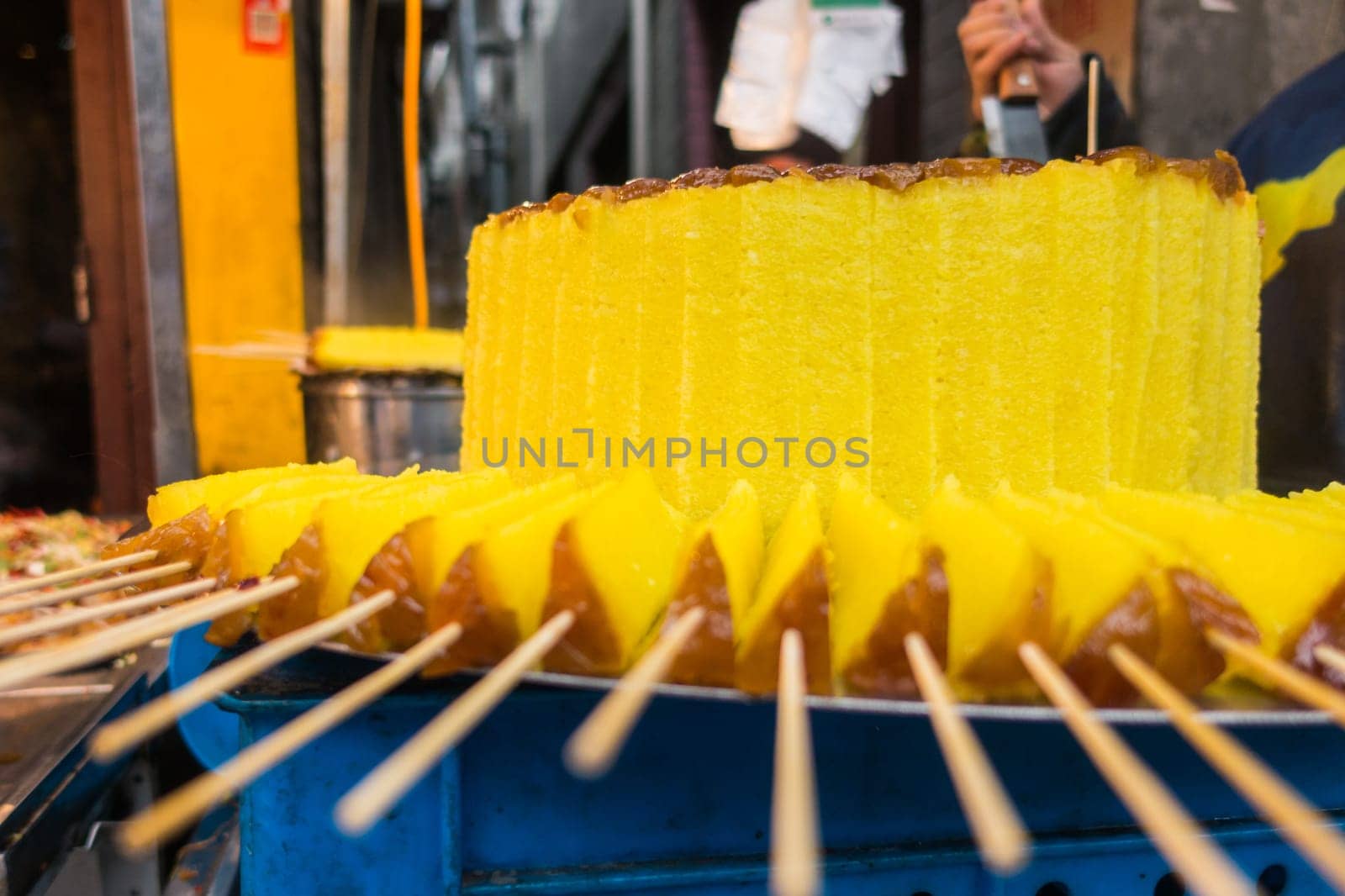 Sweet Brightly Colored Yellow Cake at Traditional Chinese Market with Sticks