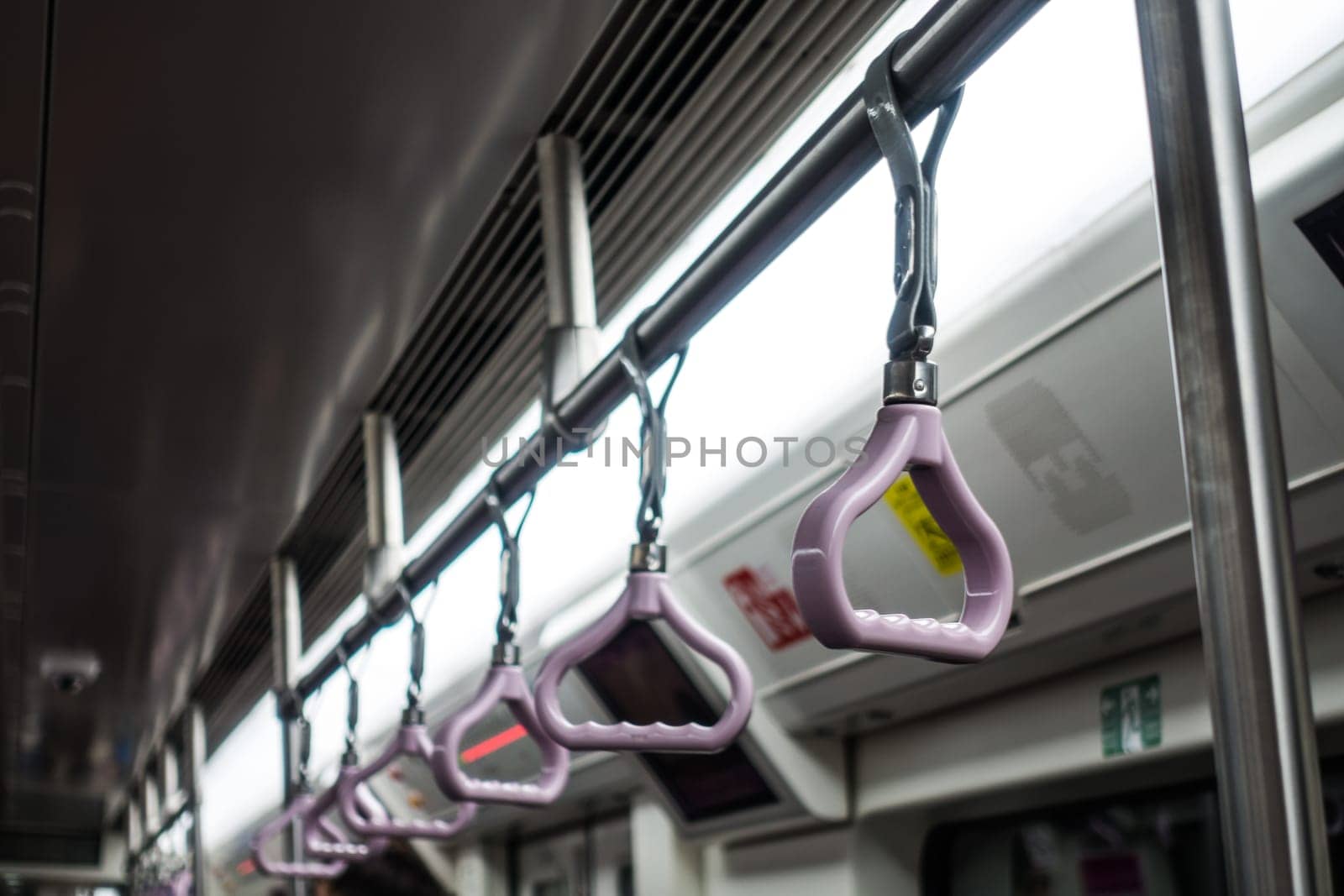 Hand Grips Row on Subway Under Flourescent Light Asian Subway