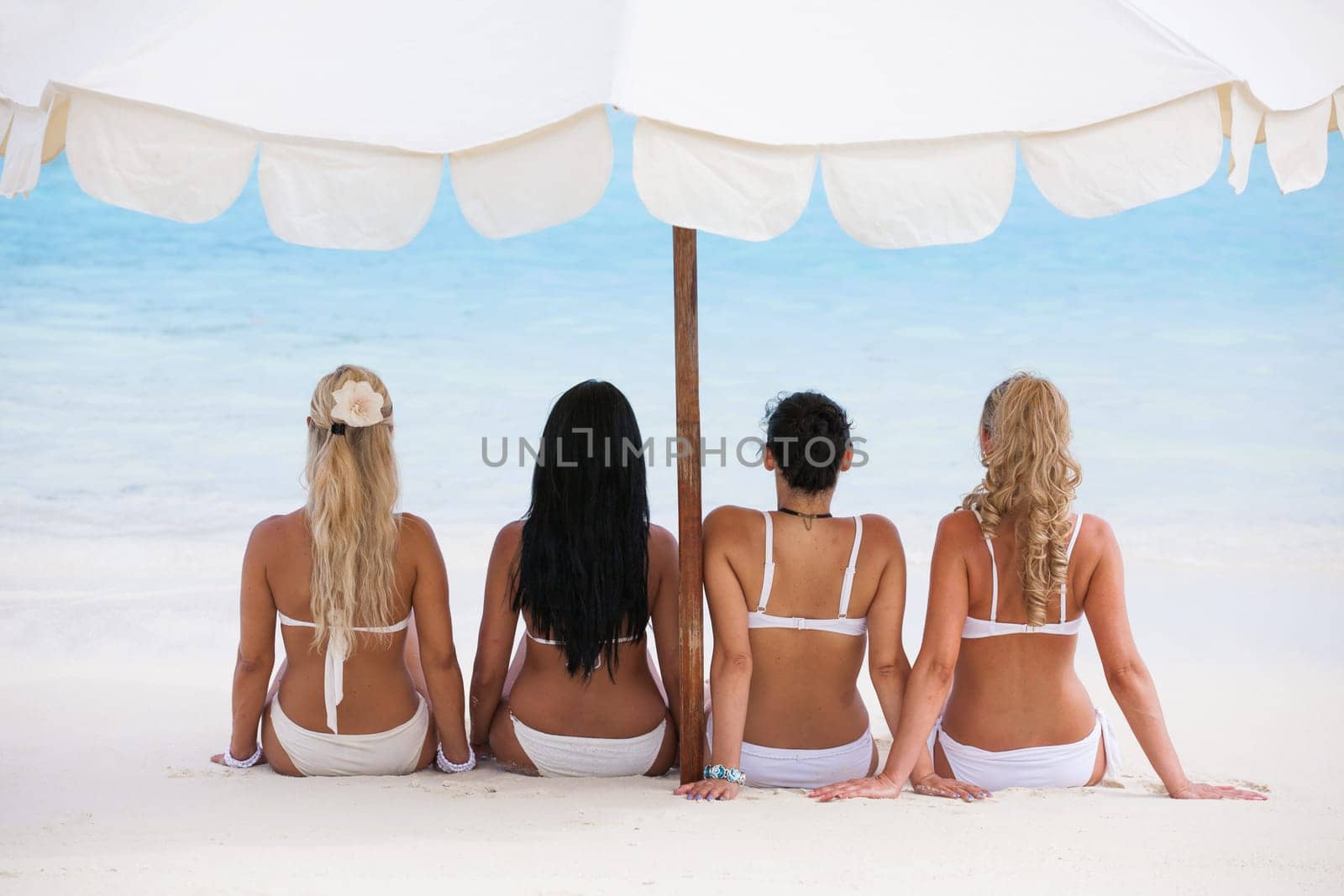Happy young women in bikinis on summer beach