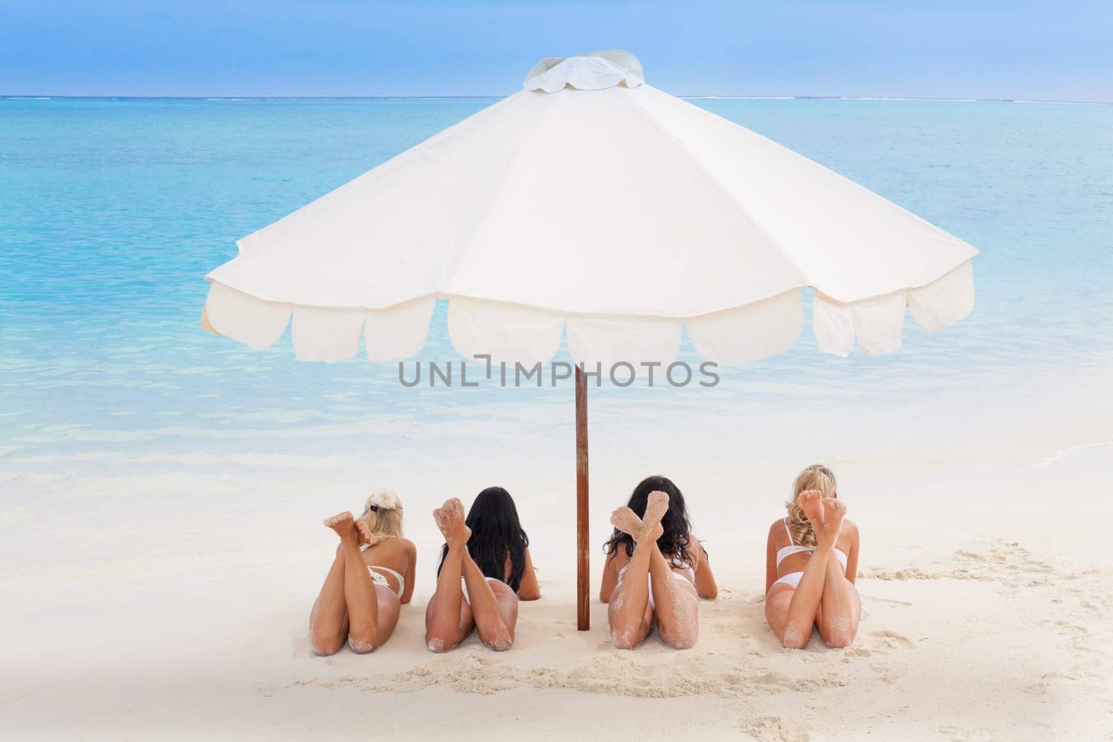 Happy young women in bikinis on summer beach