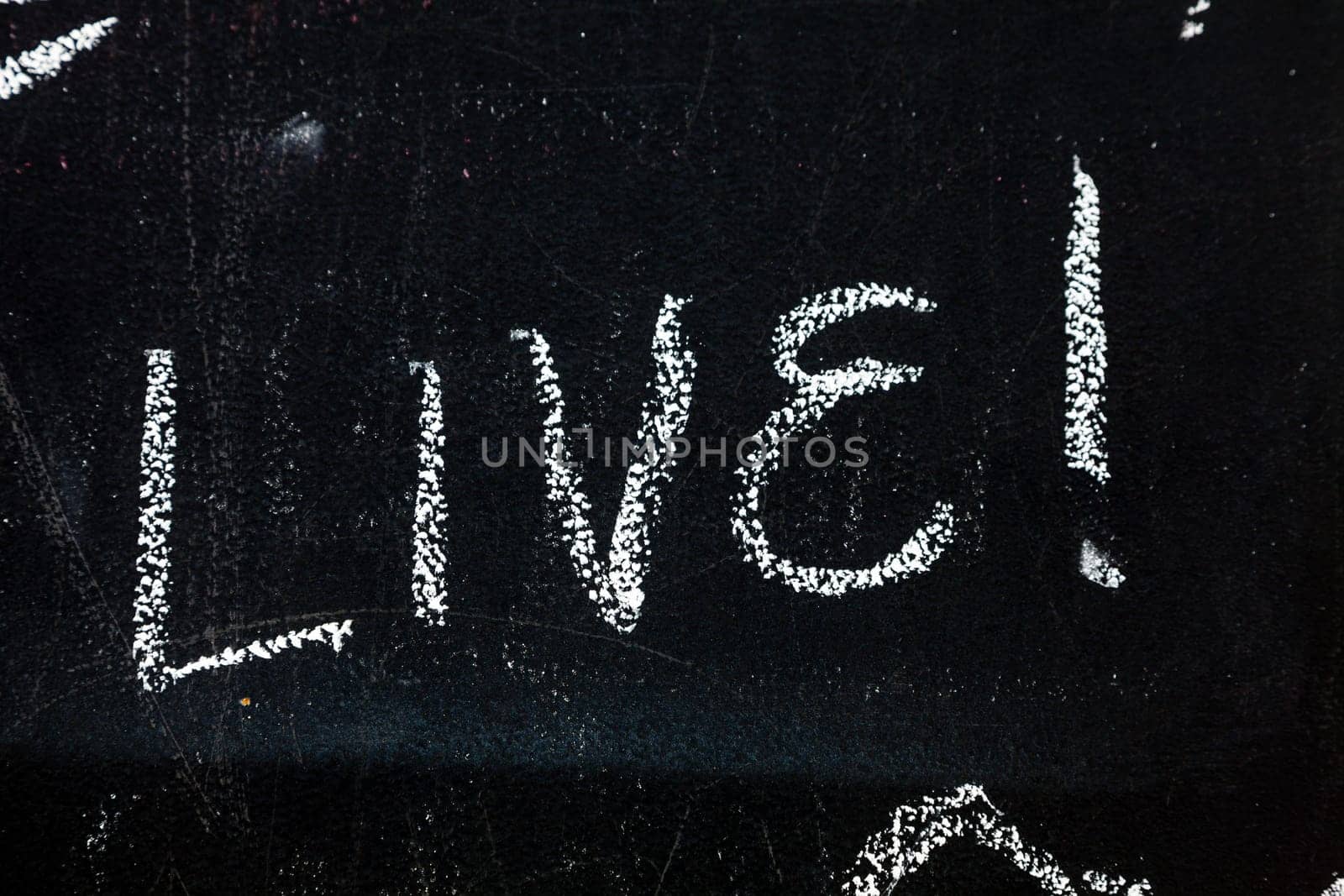 Fragment of a blackboard with text Live hand-written with chalk