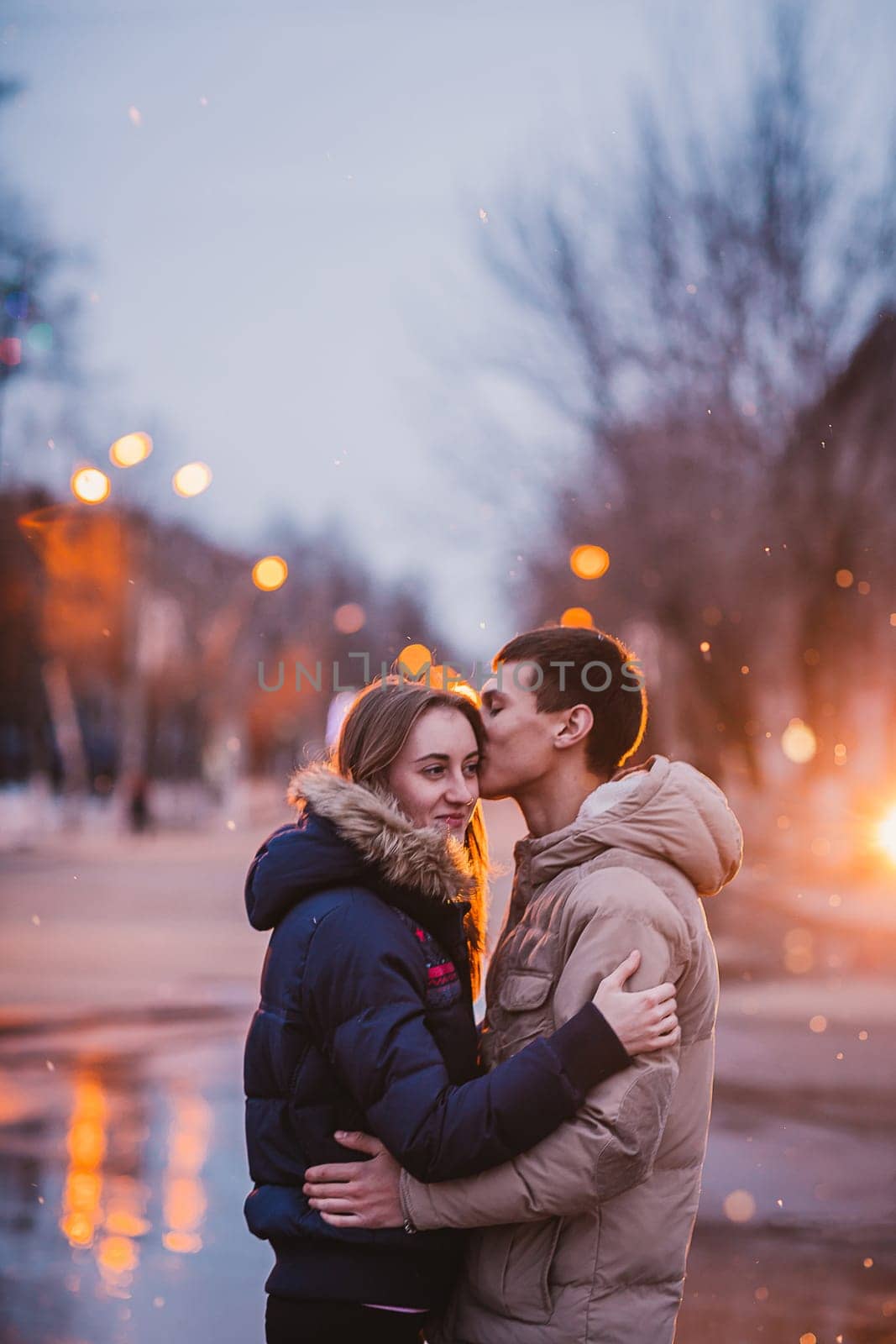 Portrait of young beautiful couple kissing in an autumn rainy day. Love and couple relationships concept.