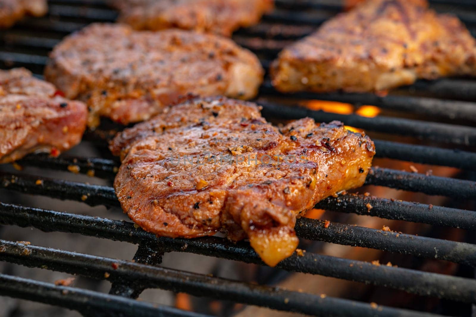 grilled pork with flames on charcoal barbecue