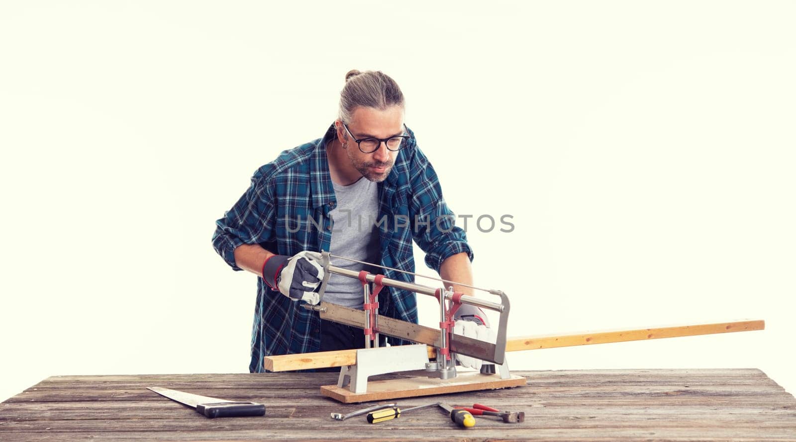 worker in blue plaid  shirt sawing wood