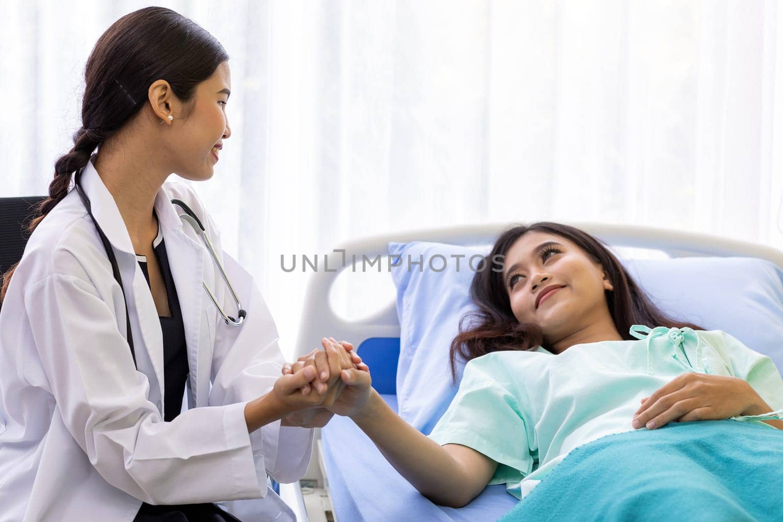 medical doctor holding patient's hands to cheer up patient