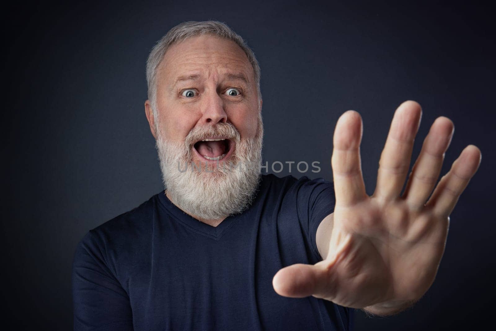 Elderly man in shirt and scared with his stretched hand forward for stopping something
