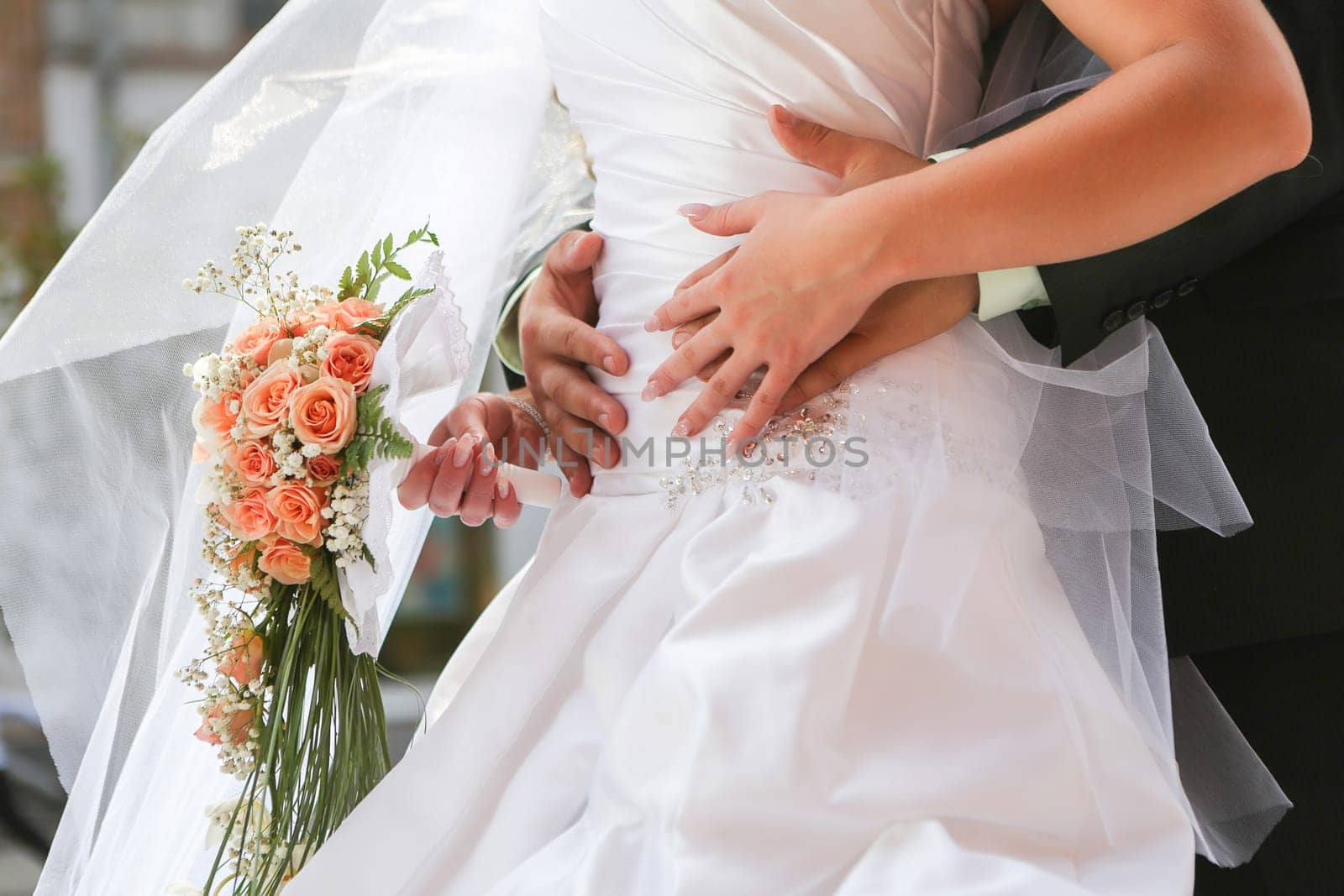 Bride with groom holding wedding bouquet at ceremony