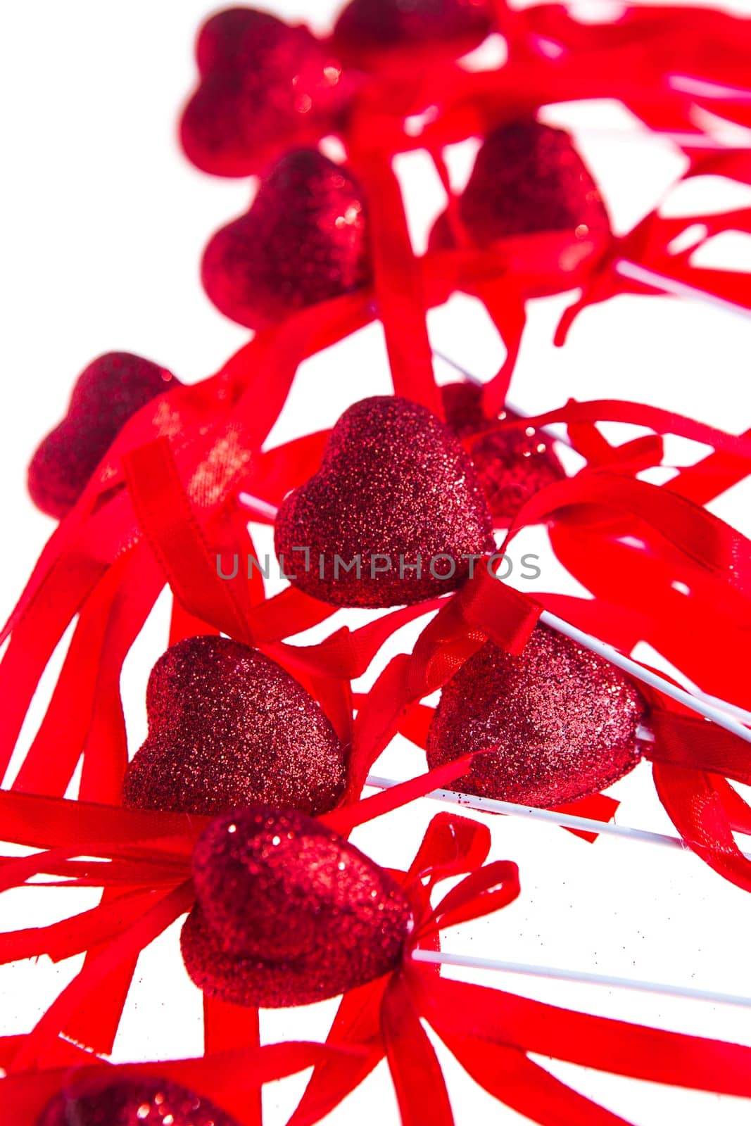 Red valentine heart shaped decorations with ribbon and bows isolated over white background.