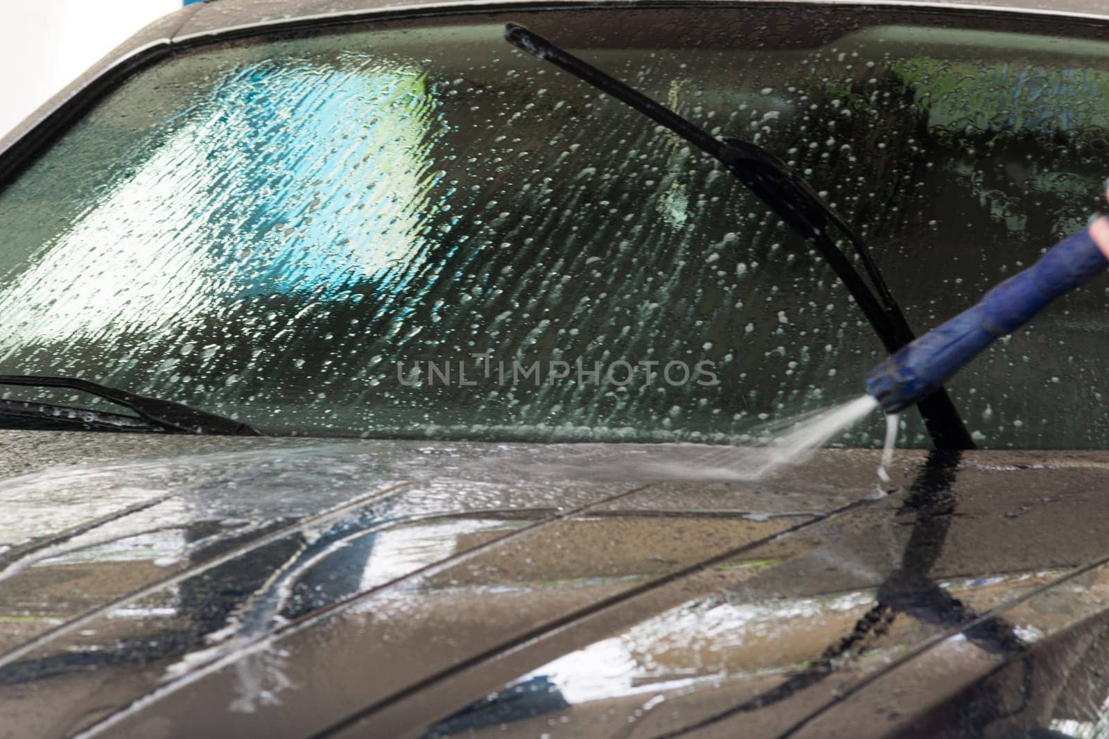 Manual car wash with pressurized water in the car wash outside.