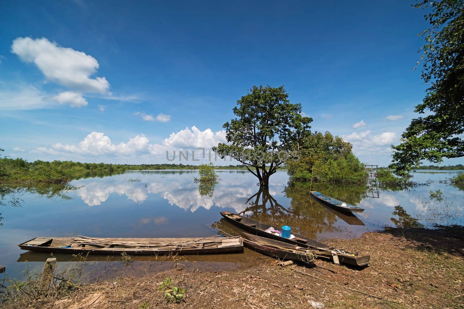 Flooded Landscape With Fishing Boats, standing water with reflection of clouds