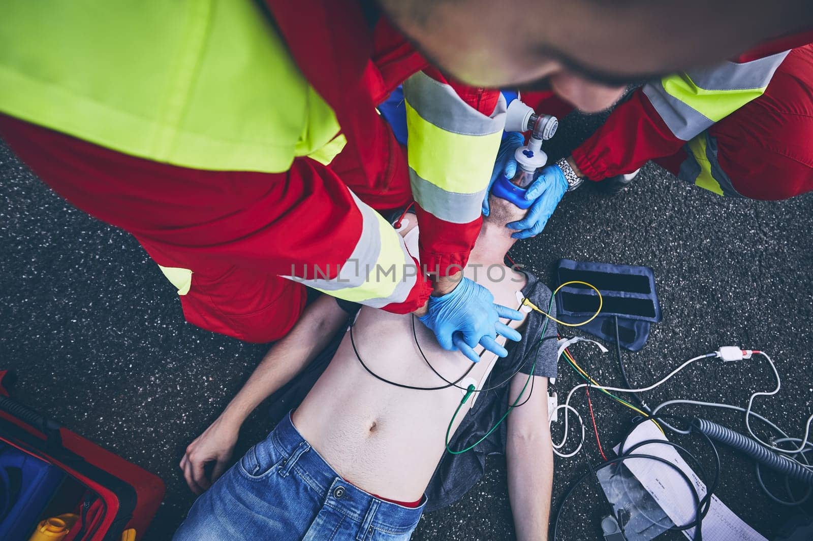 Cardiopulmonary resuscitation. Rescue team (doctor and a paramedic) resuscitating the man on the road.