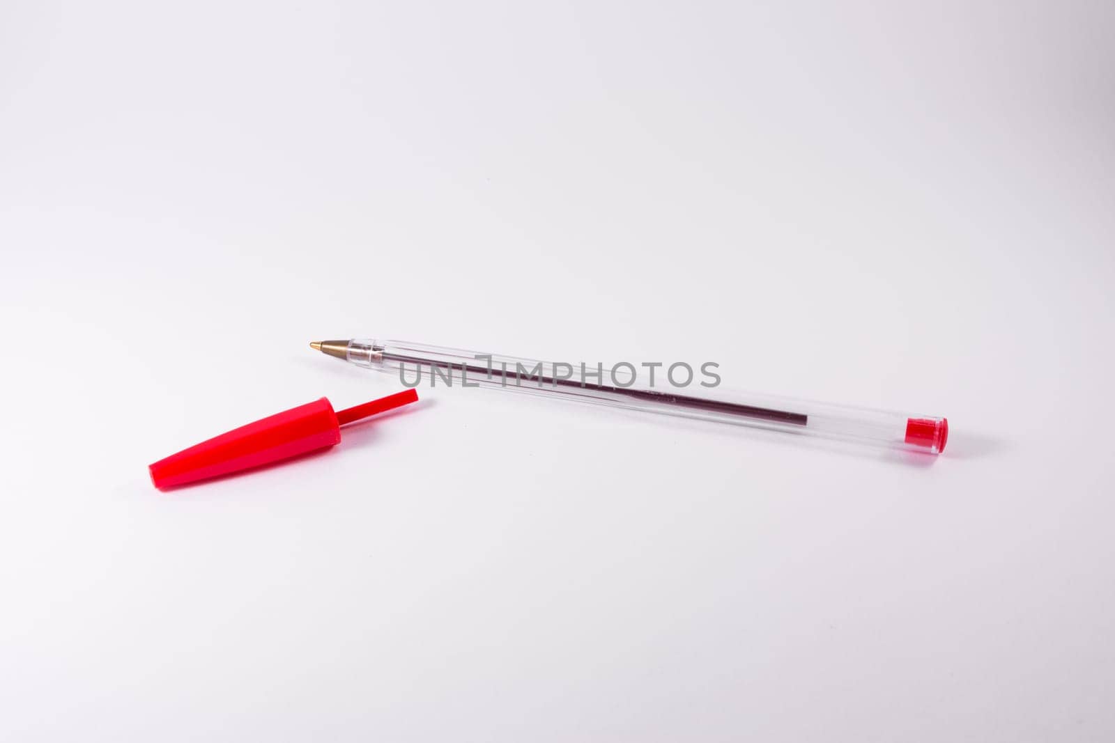 Red Pen Tip Cap Tube Plastic Clear Office Supply White Background Closeup