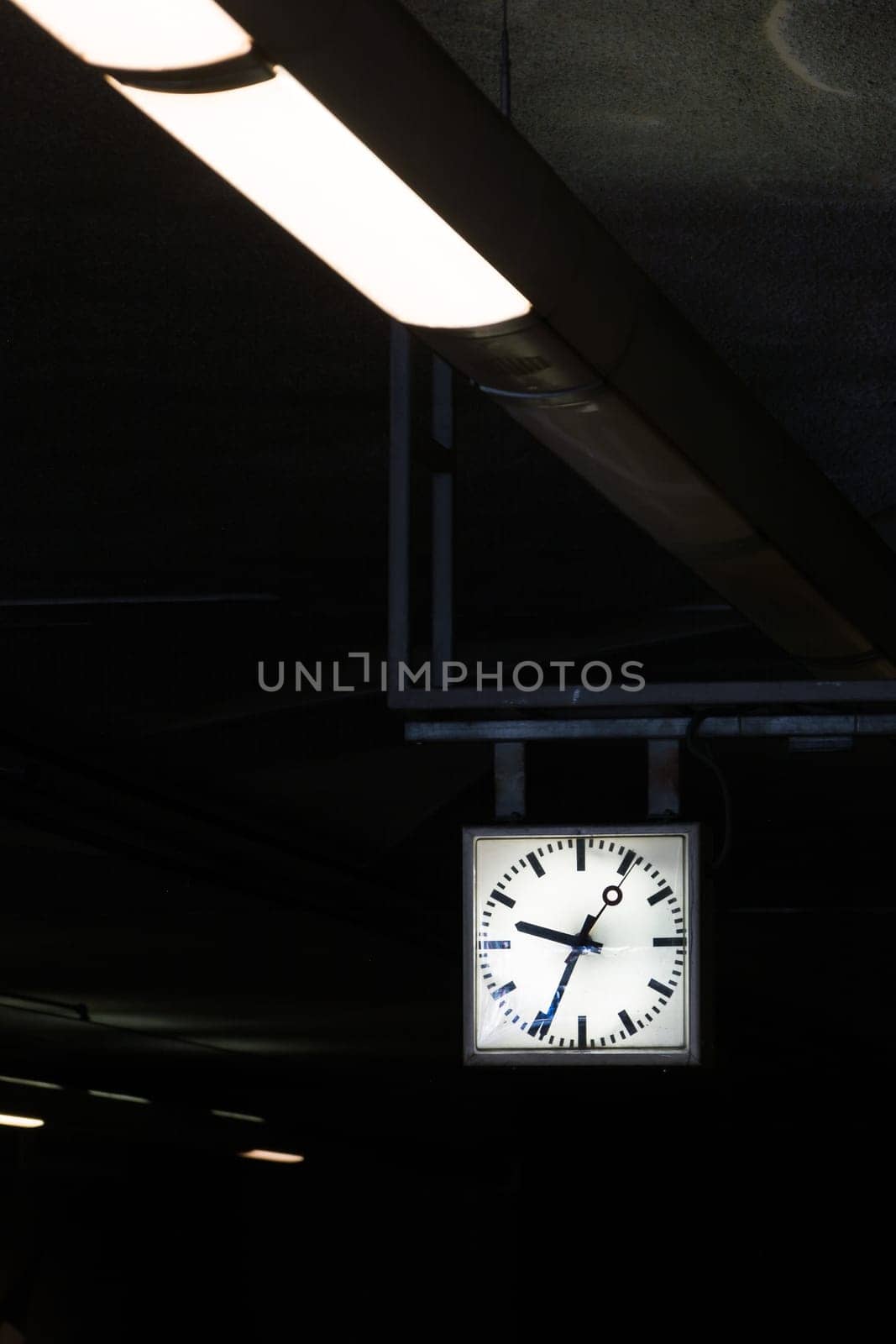 Contrast Diagonal Flourescent Lights Leading to Square Geometric Clock Time Architecture