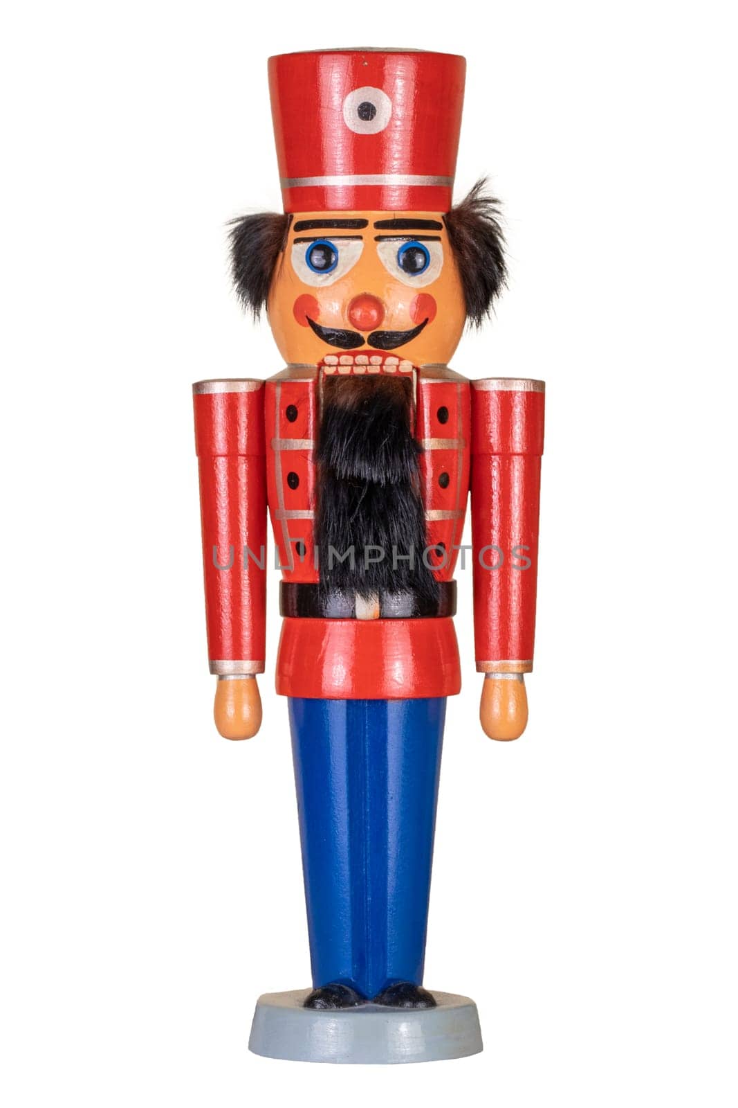 Christmas decoration background. Closeup of a christmas vintage wooden traditional nutcracker figurine isolated on a white background. Soldier in red uniform.